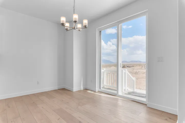 Spacious room featuring wood-finish flooring and a modern chandelier