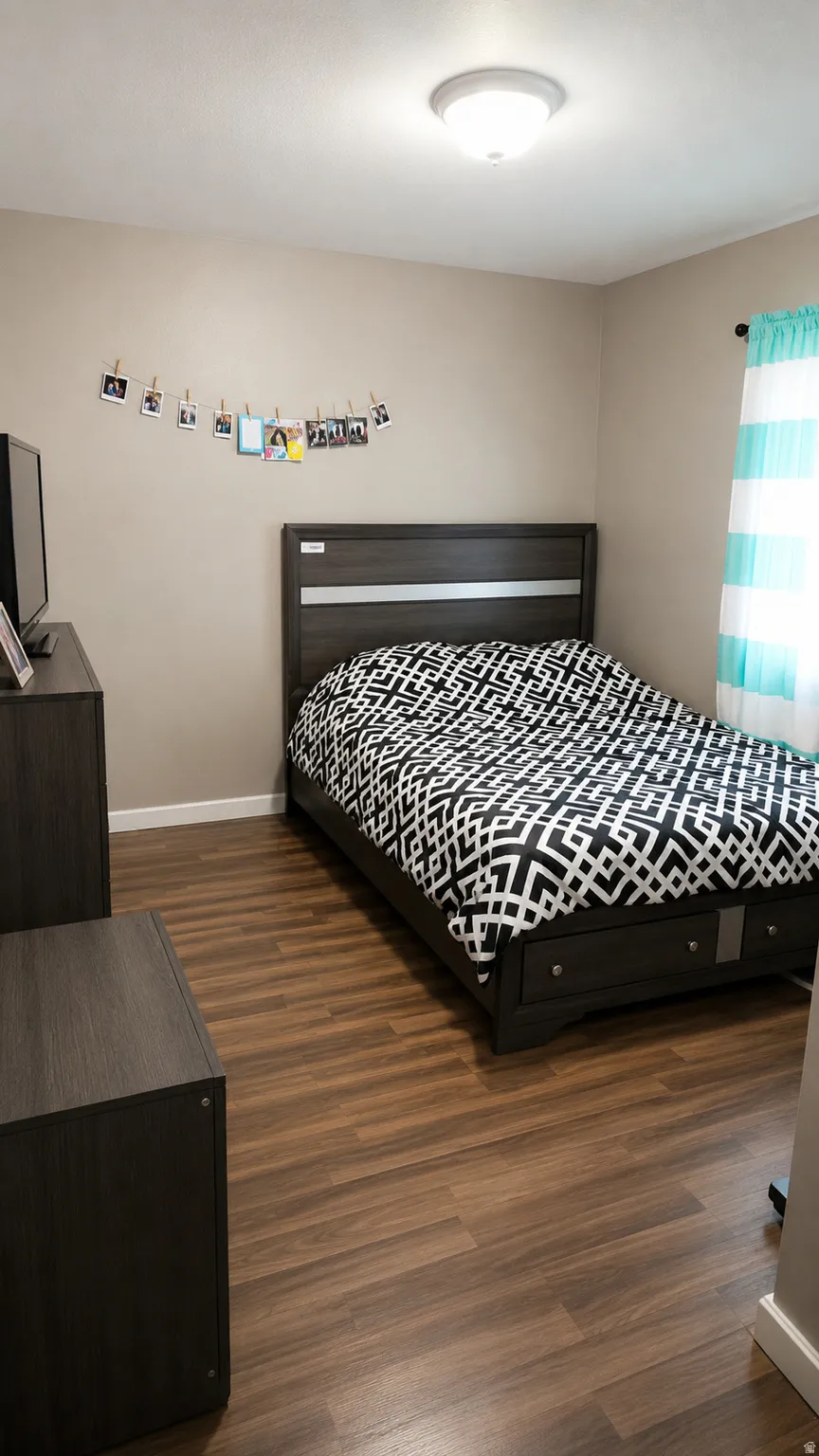 Bedroom featuring wood-finish flooring, a neutral wall color, and a flush-mount ceiling light fixture