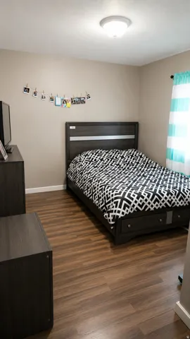 Bedroom featuring wood-finish flooring, a neutral wall color, and a flush-mount ceiling light fixture