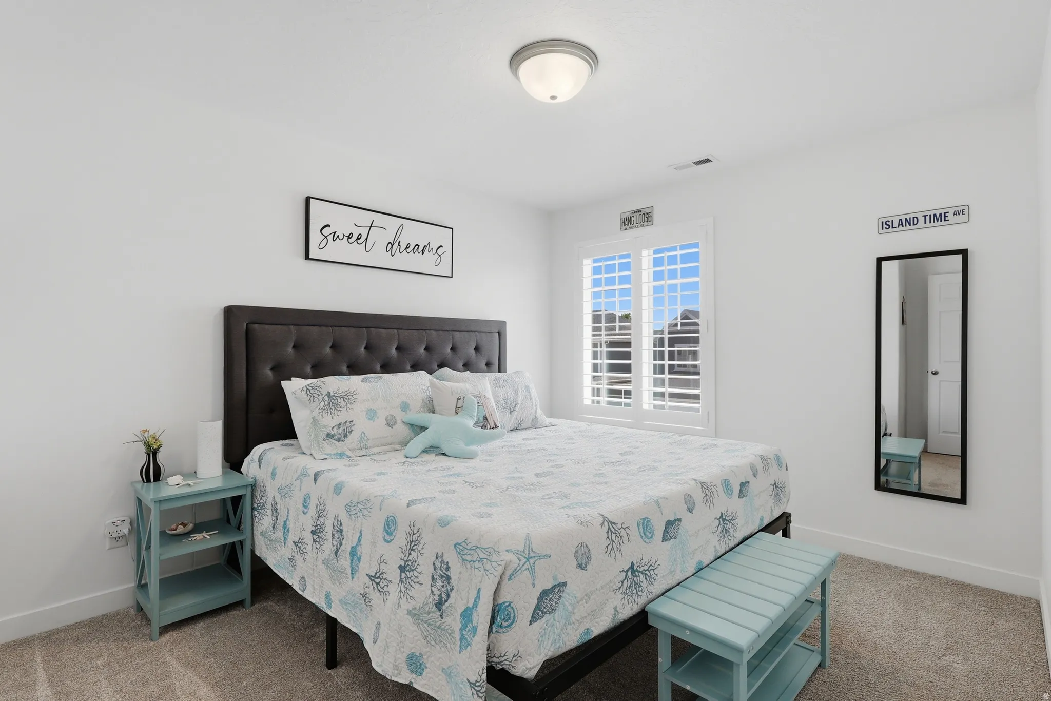 Neutral wall finishes with a tufted headboard, plantation shutters, and a semi-flush mount ceiling light
