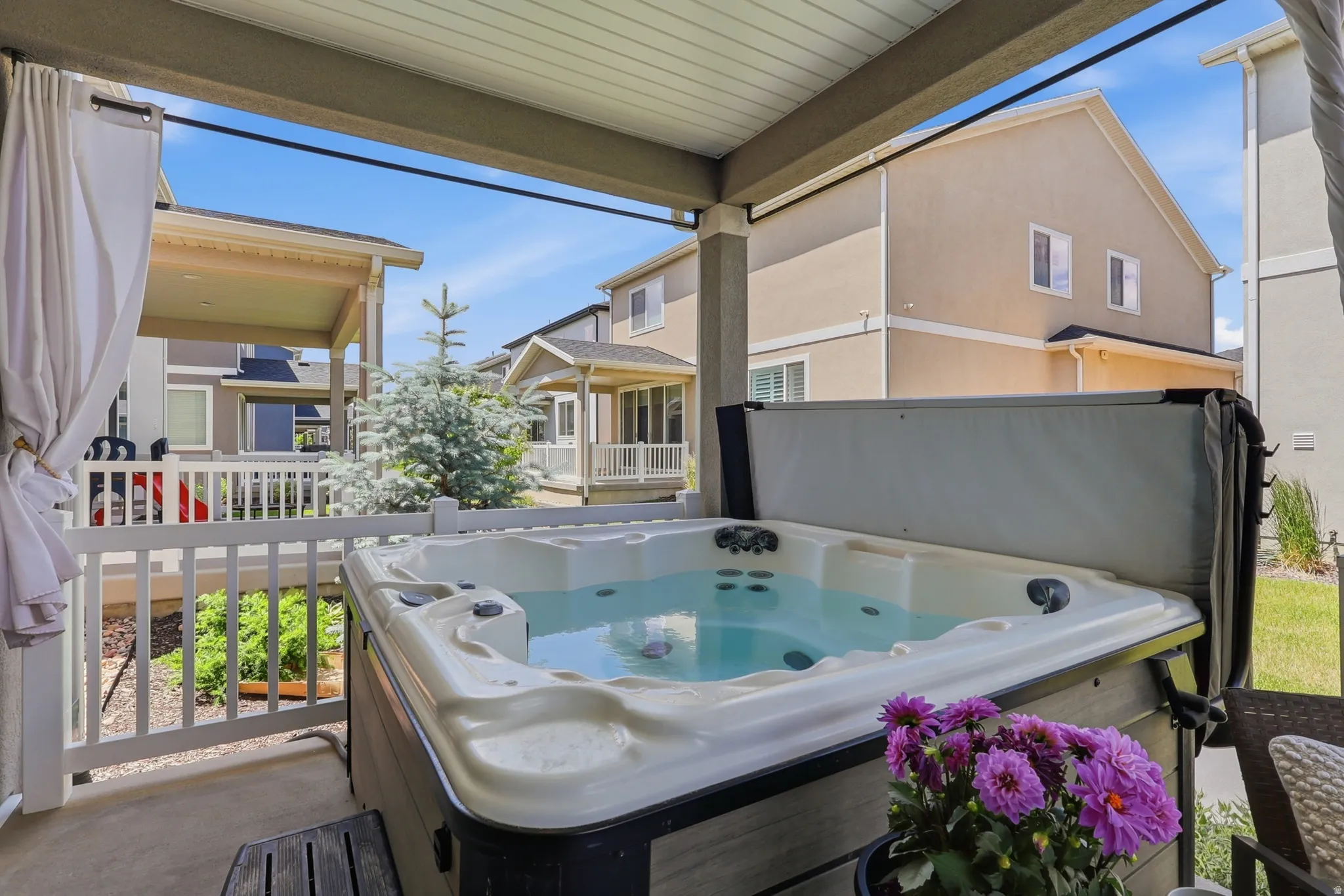Covered patio featuring a built-in hot tub with a light-colored interior and dark-toned exterior