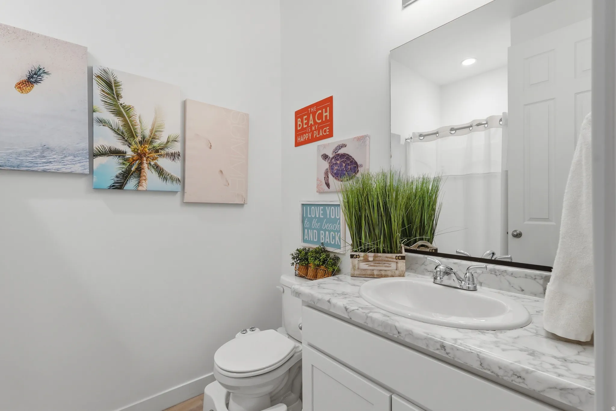 Vanity with a white oval sink and chrome faucet, set against a marble-look countertop