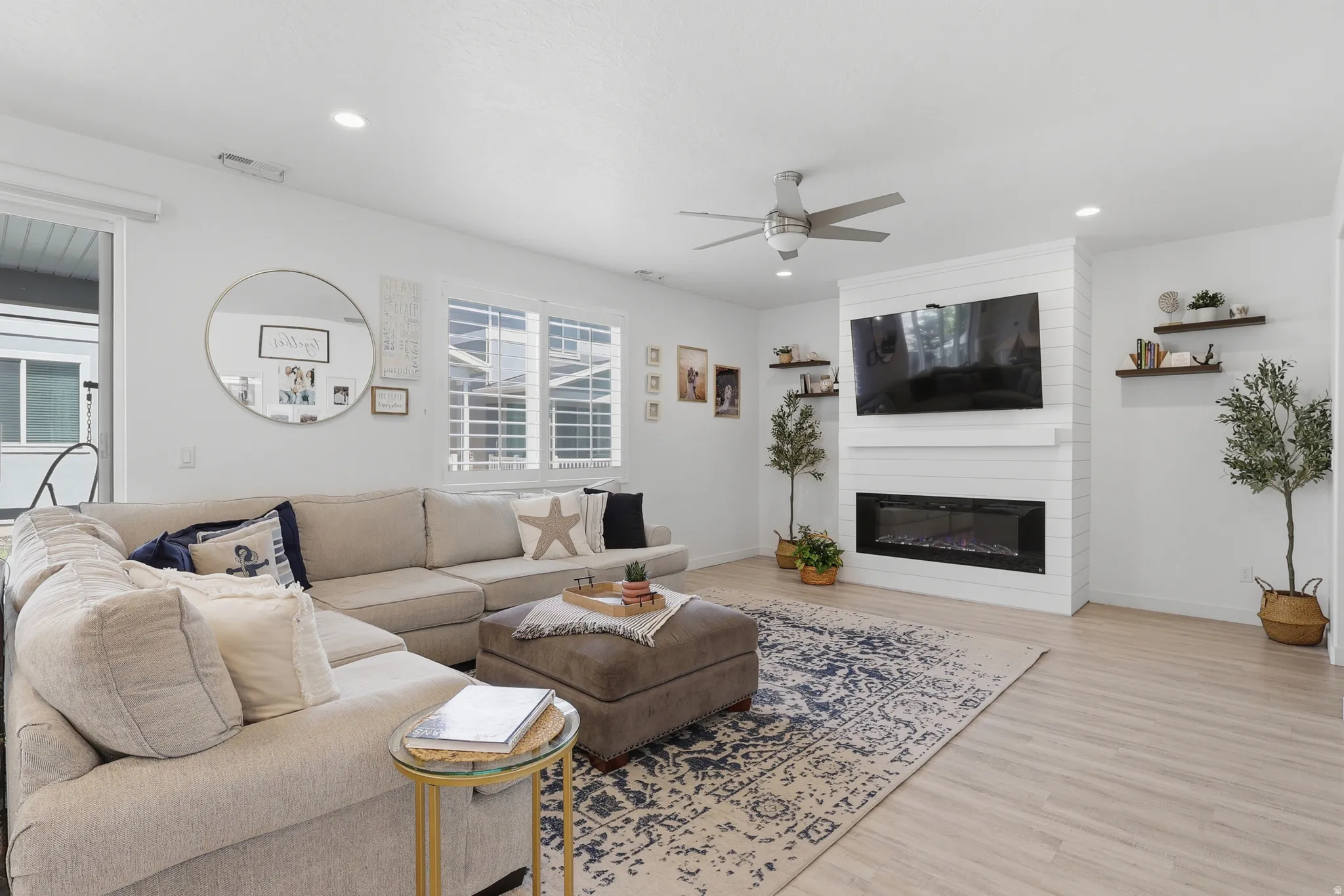 Living area featuring wood-finish flooring, a contemporary ceiling fan, and recessed lighting