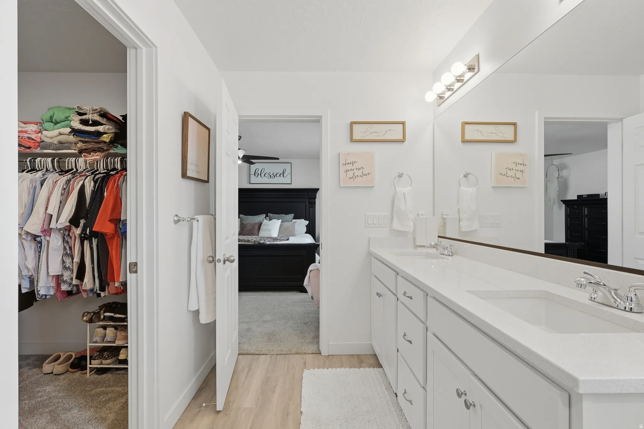 Double vanity with integrated sinks, white cabinetry, and polished chrome hardware