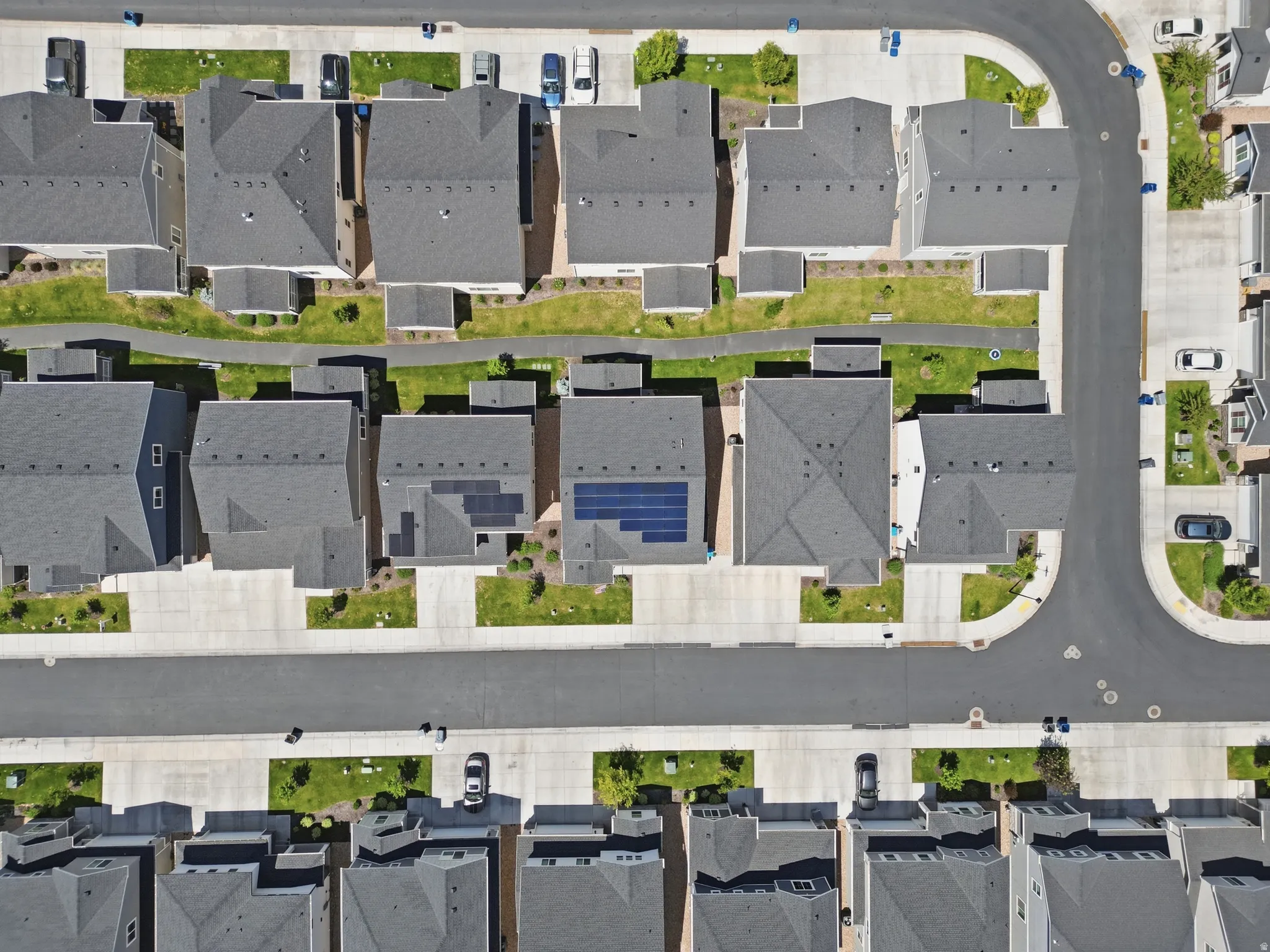 Aerial perspective showcasing a residential community with uniform gray-shingled rooftops