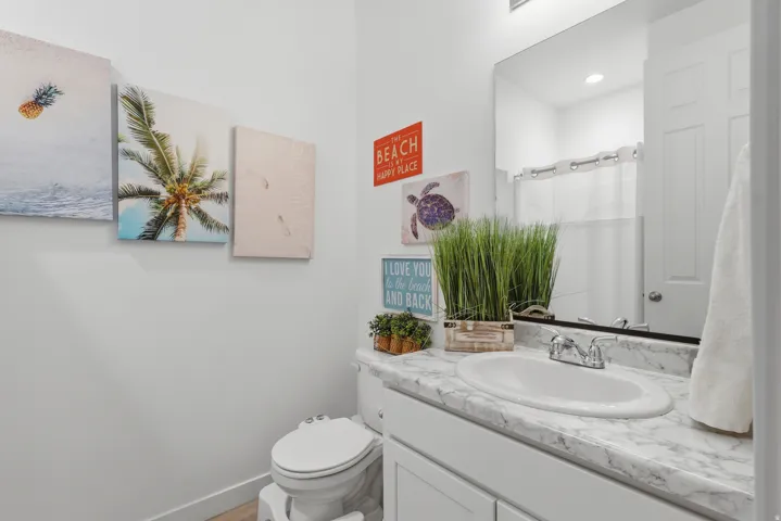 Vanity with a white oval sink and chrome faucet, set against a marble-look countertop
