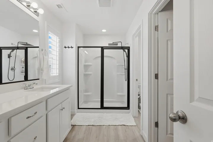 Bathroom featuring a white vanity with an integrated sink, light-colored countertop, and ample storage cabinetry