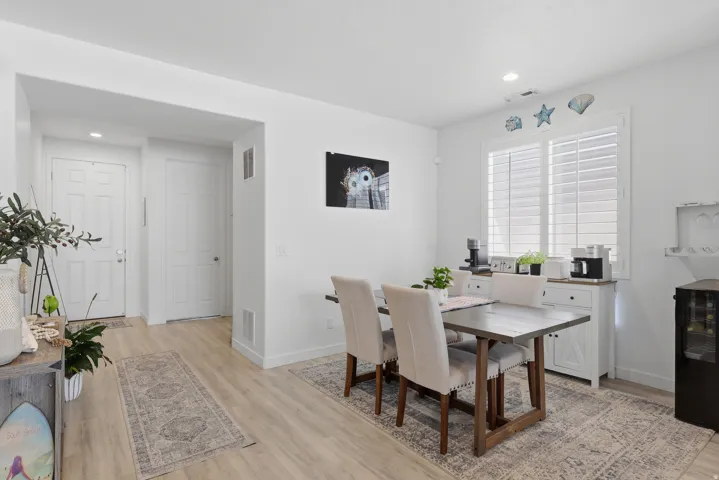 Open-concept dining area featuring wood-finish flooring and white walls