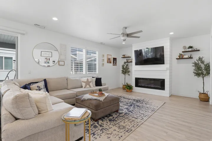 Living area featuring wood-finish flooring, a contemporary ceiling fan, and recessed lighting