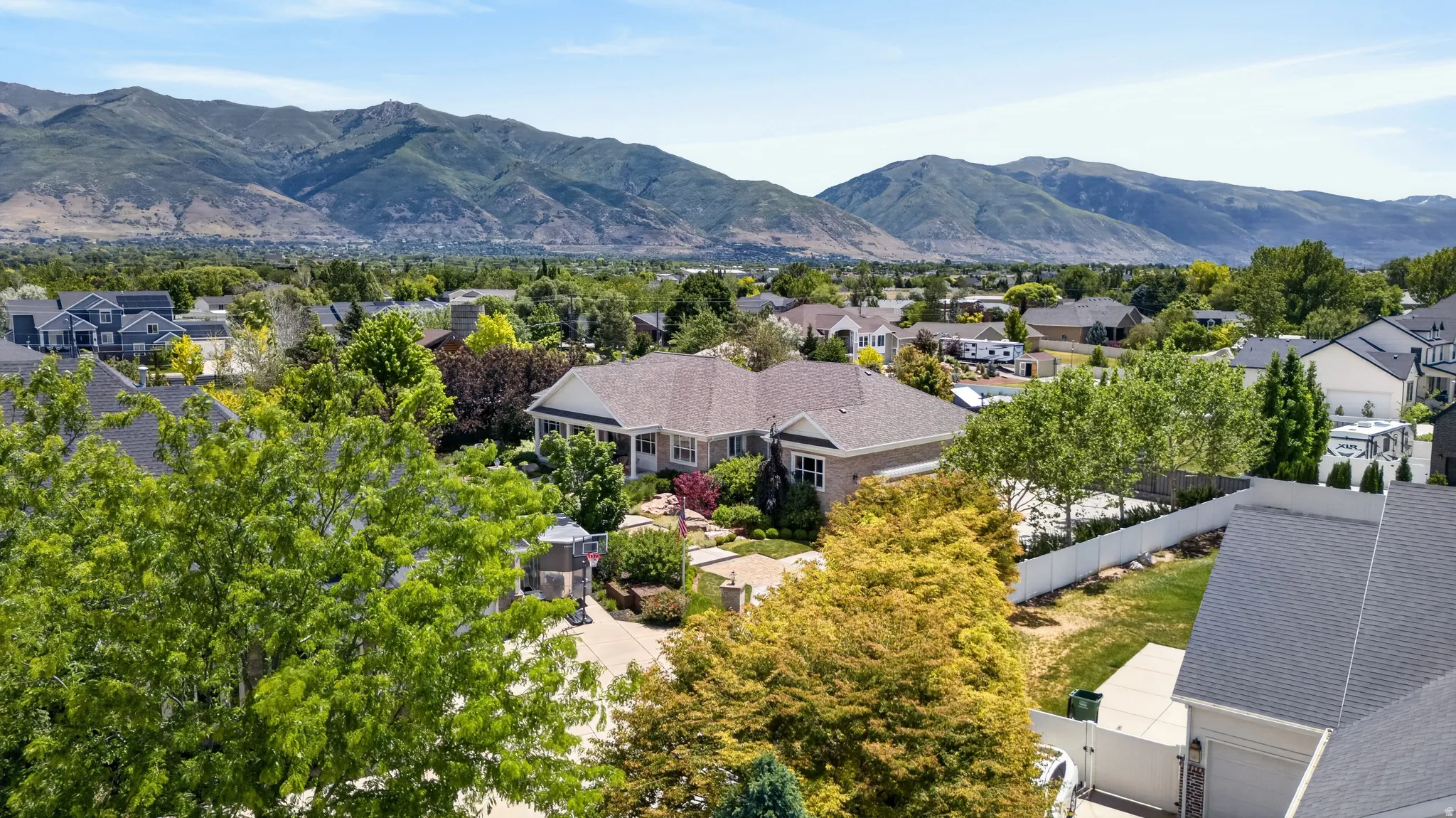 Expansive lot featuring a single-story residence with a covered front porch, brick facade, and a paved driveway