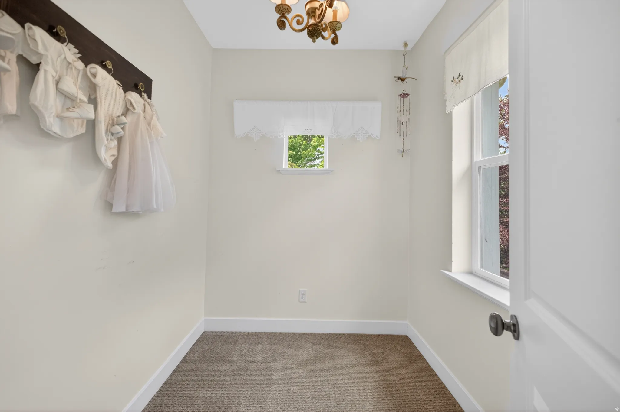 Compact room featuring two windows, neutral wall tones, and a single ceiling fixture