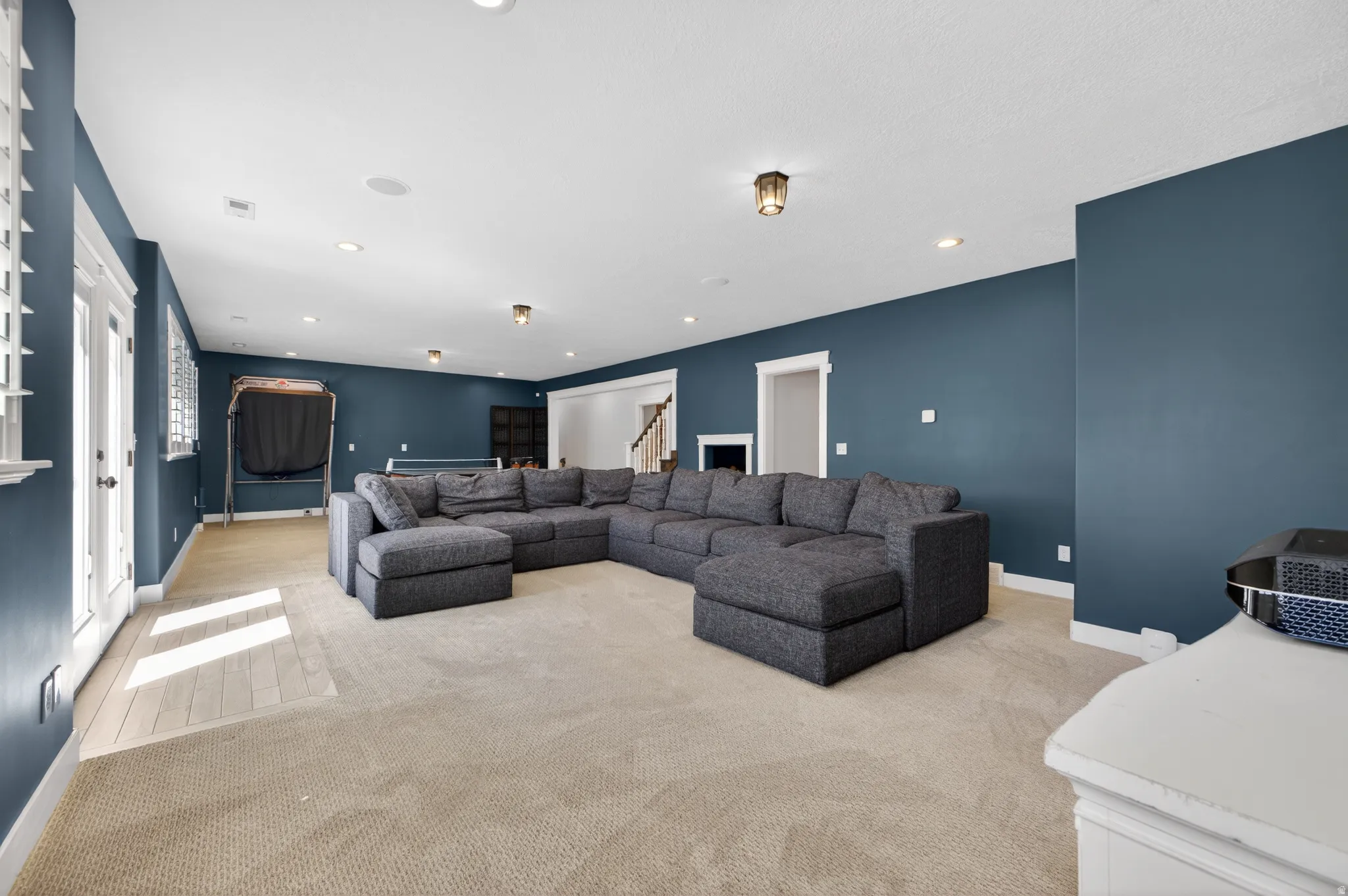 Spacious recreation room featuring recessed lighting, a ceiling-mounted light fixture, and plush carpeting
