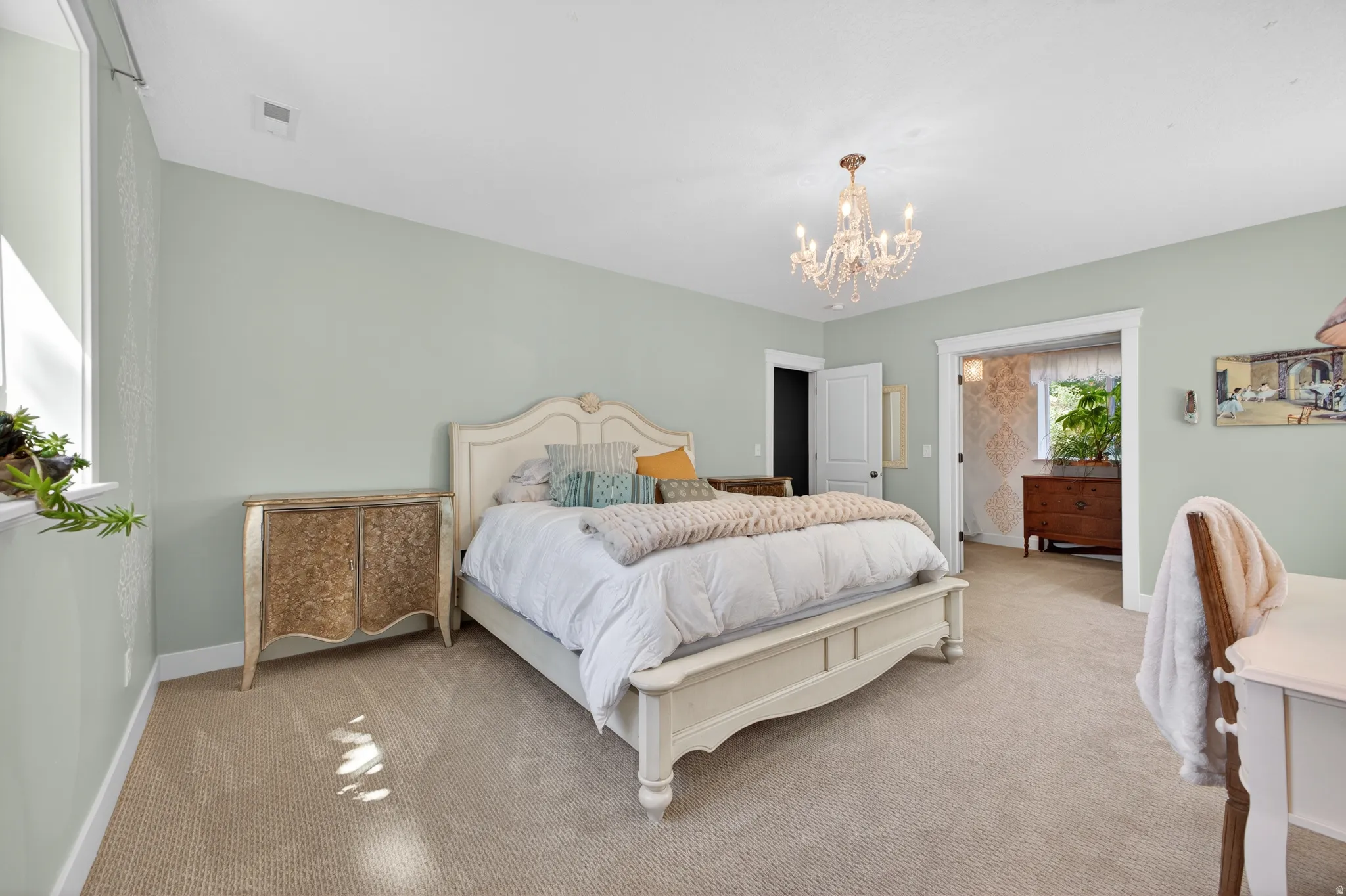 Spacious bedroom featuring light neutral wall tones and plush carpeting