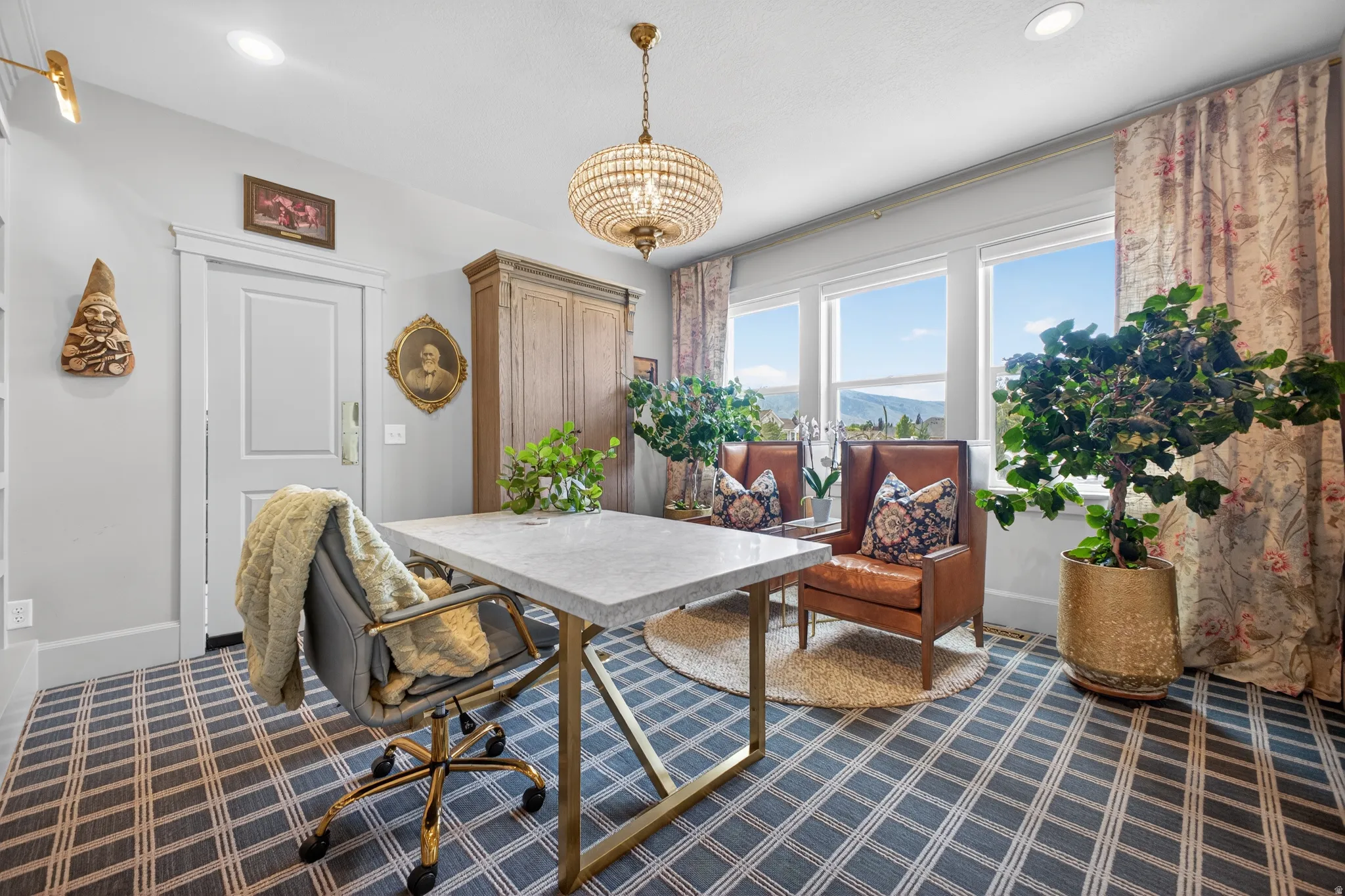 Light-filled room featuring multiple windows with mountain scenery, a decorative chandelier, recessed lighting, and a patterned floor covering
