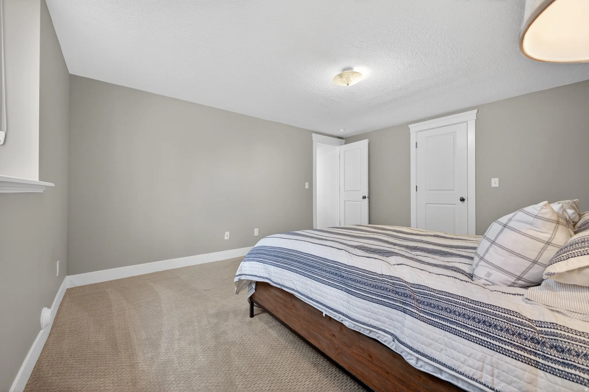 Carpeted room featuring light gray walls, white baseboards, and a window with a white sill