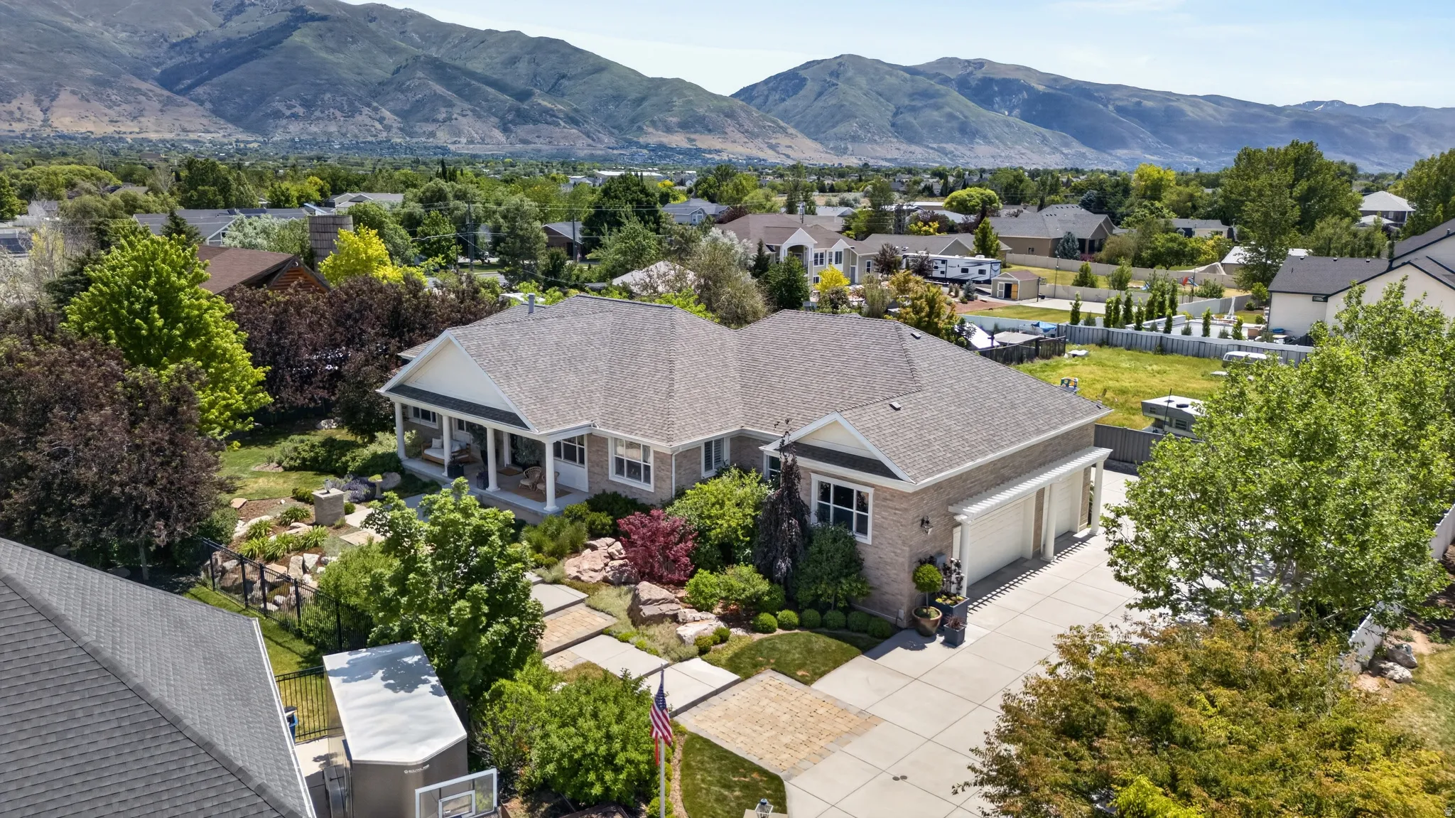 Ranch-style residence featuring a prominent front porch with columns, a multi-car garage, and a concrete driveway
