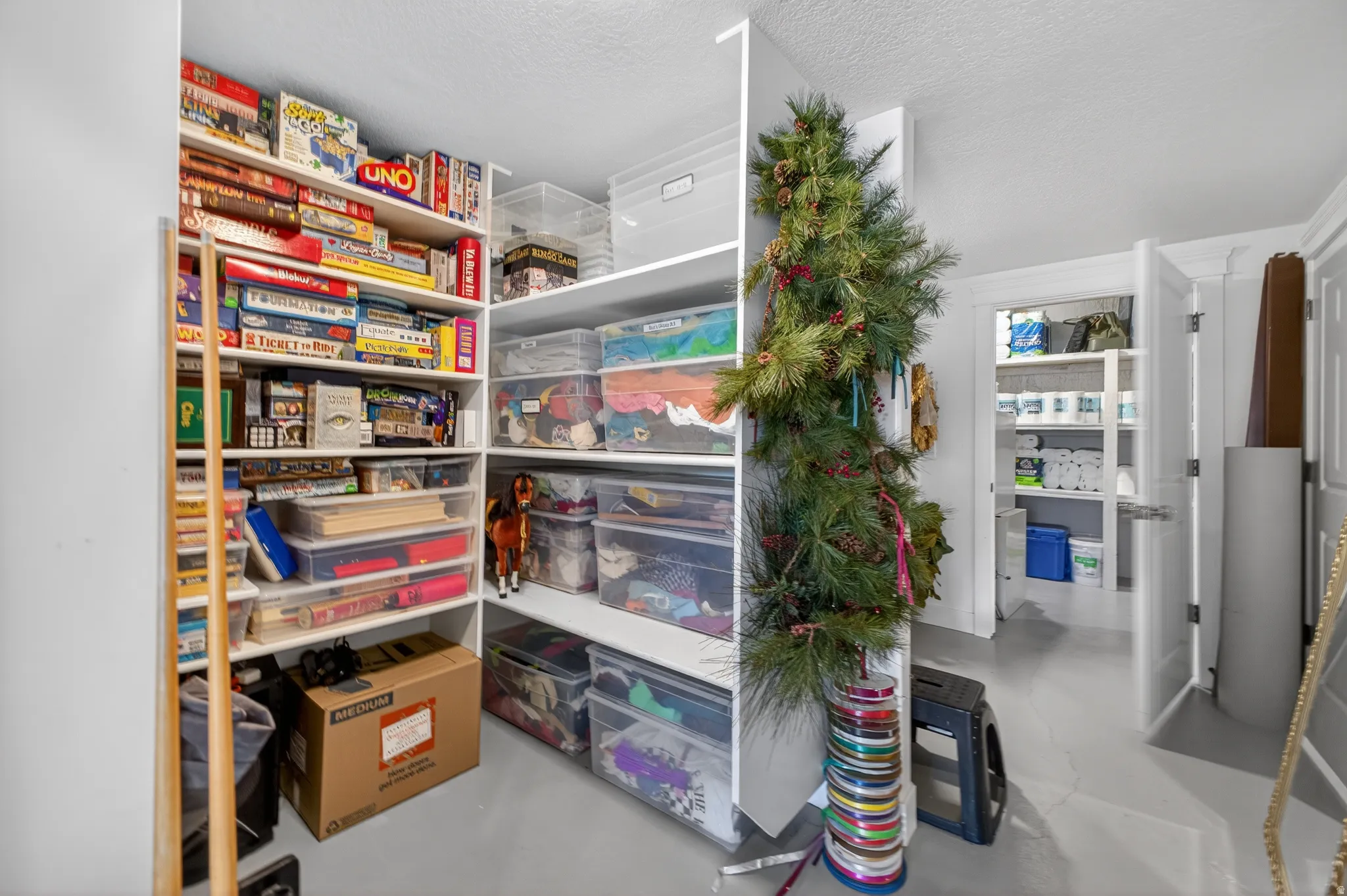 Built-in shelving system with white finishes, offering extensive storage capacity within a dedicated area