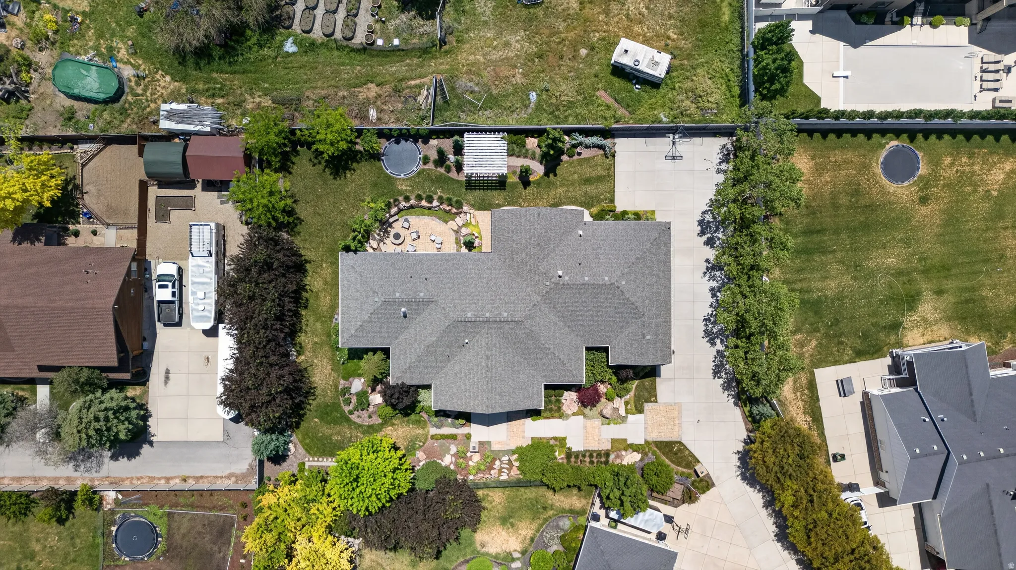The property features a large main residence with a gabled roofline, extensive paved areas, and mature landscaping