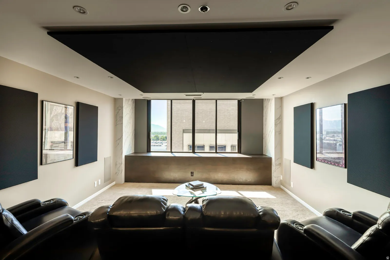 Dedicated media room featuring a large, dark ceiling panel and recessed lighting