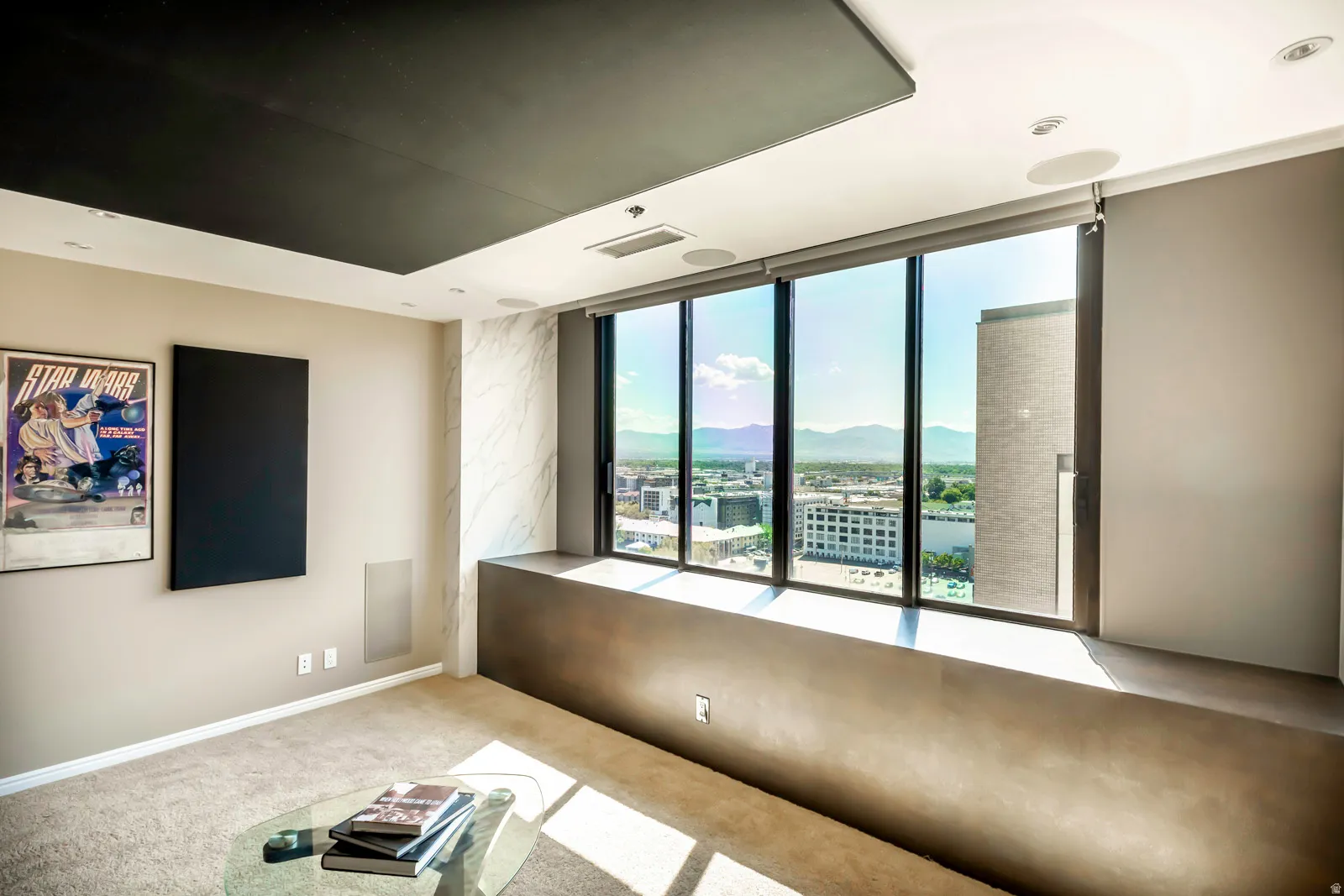 Floor-to-ceiling windows with roller shades, a built-in window bench, a recessed ceiling panel, recessed lighting, and integrated ceiling speakers