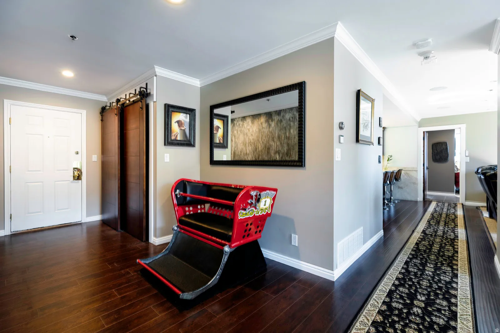 Entryway featuring dark wood-finish flooring, a white paneled entry door, and a barn door system
