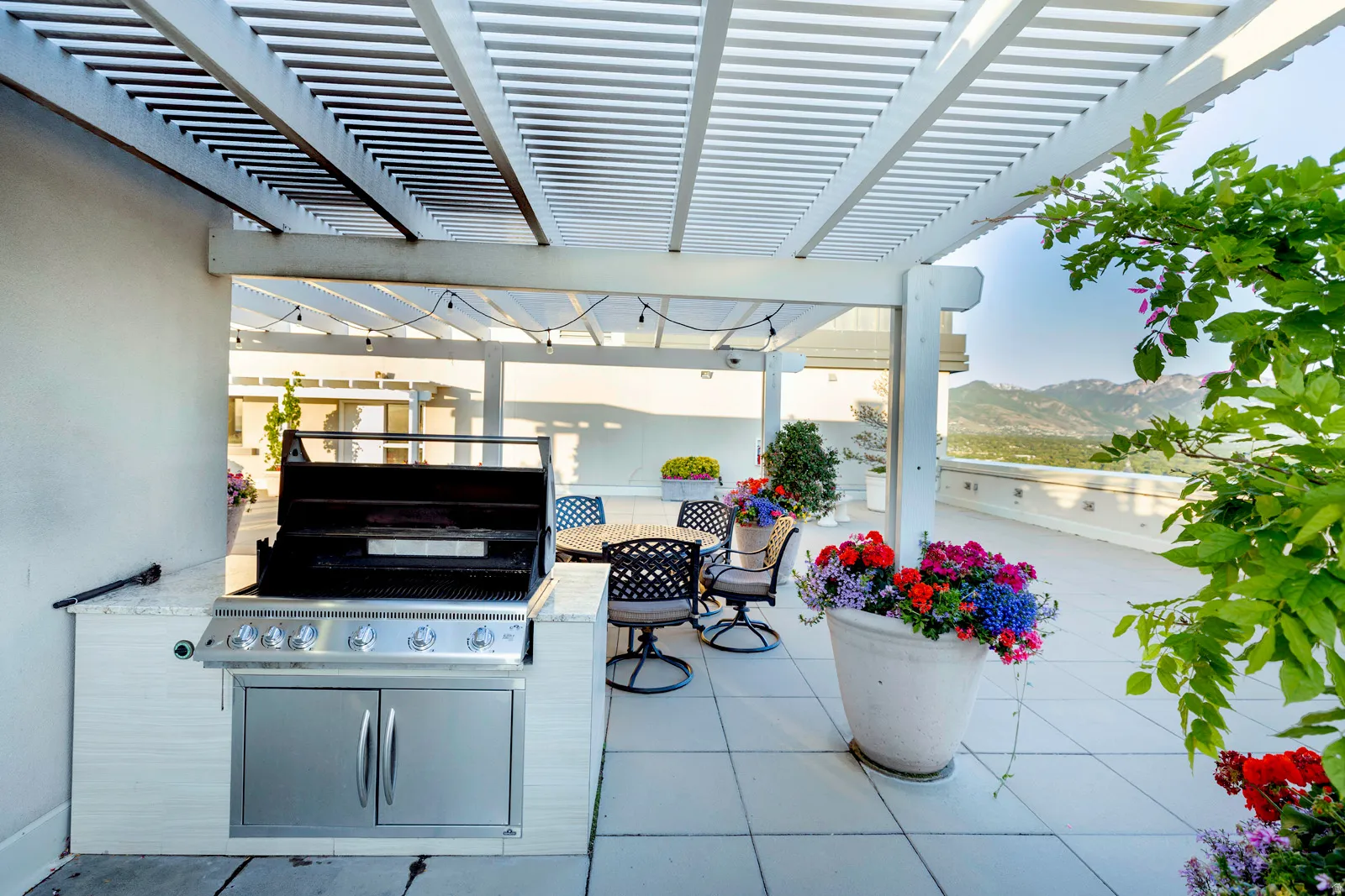 Expansive outdoor patio featuring an integrated built-in grill with stainless steel cabinetry