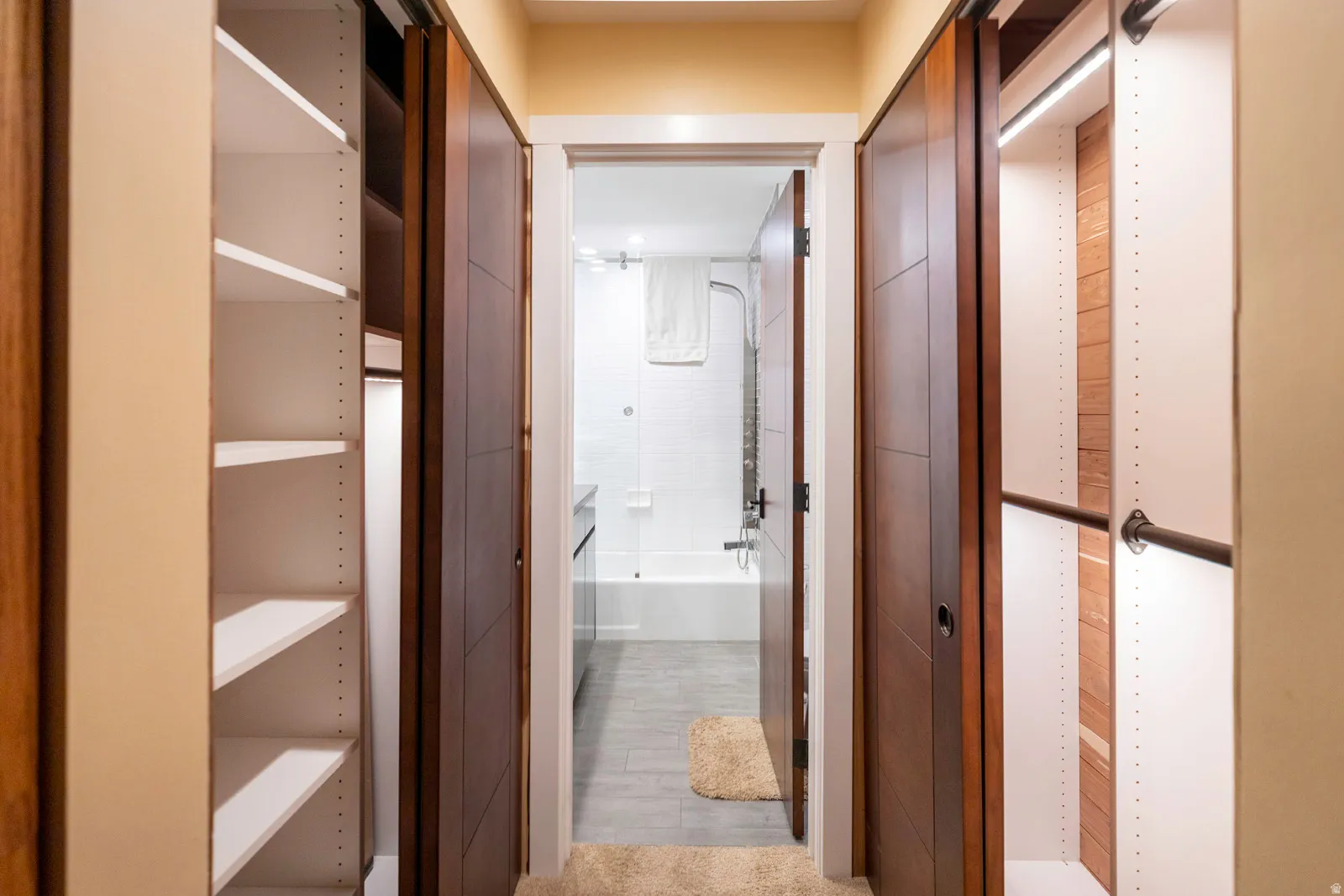Hallway featuring dual sliding wood-paneled doors on overhead tracks