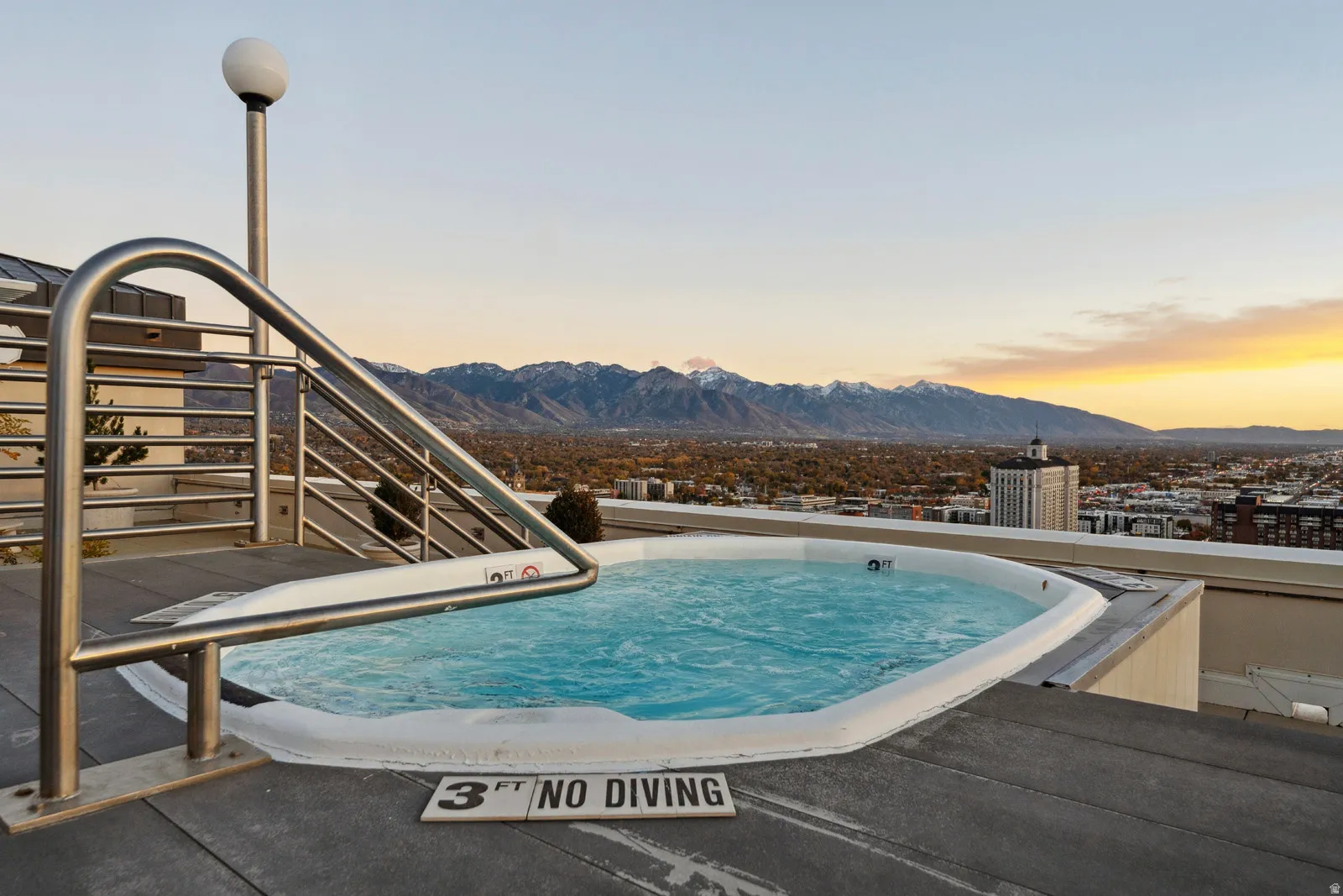 Rooftop spa featuring a stainless steel handrail and surrounding composite decking