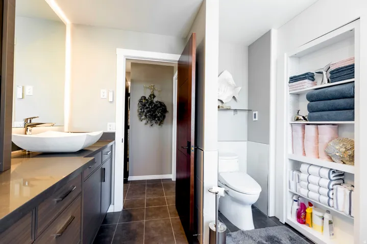 Modern vanity featuring a vessel sink, integrated countertop, and ample storage cabinetry
