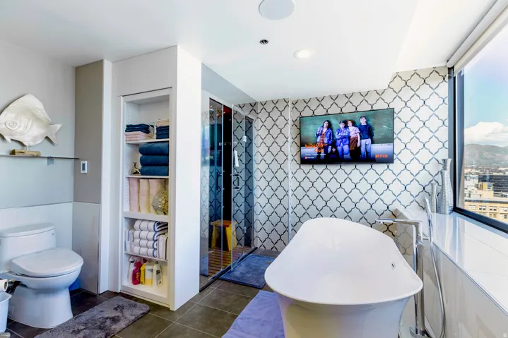 Freestanding soaking tub with floor-mounted faucet, complemented by patterned accent wall