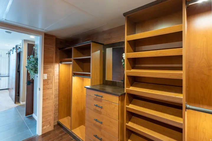 Custom wood cabinetry featuring integrated shelving, drawers, and hanging rods