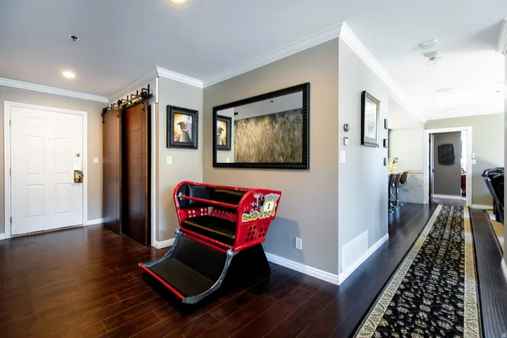 Entryway featuring dark wood-finish flooring, a white paneled entry door, and a barn door system