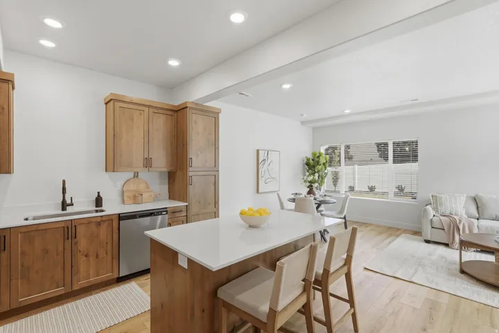 Kitchen featuring wood-finish cabinetry, stainless steel dishwasher, and a white countertop
