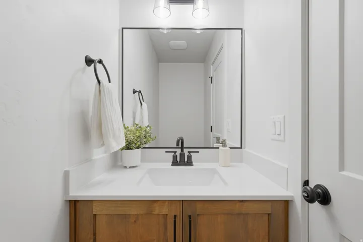 Bathroom vanity featuring an integrated sink, black matte faucet, and wood-finish cabinetry
