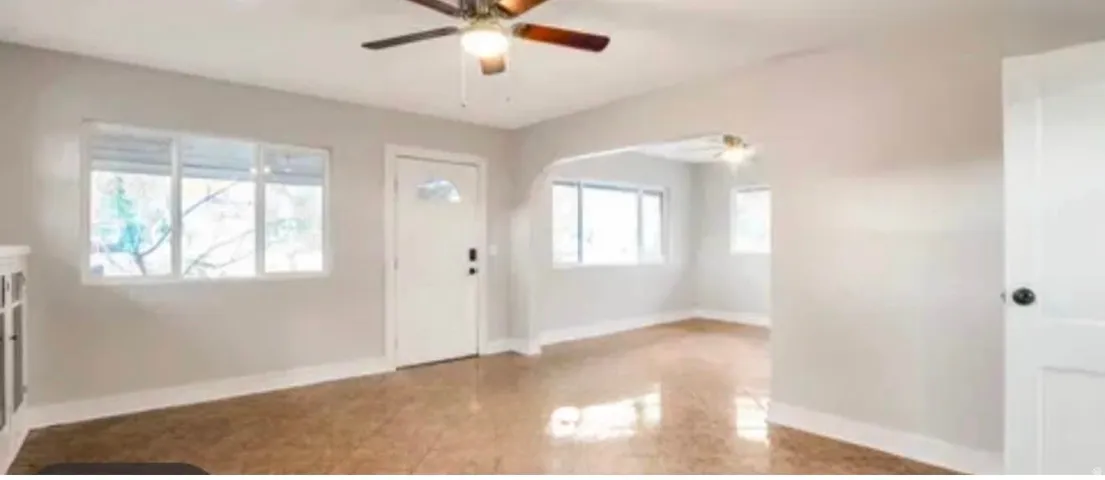 Bright living space featuring wood-finish flooring and a ceiling fan