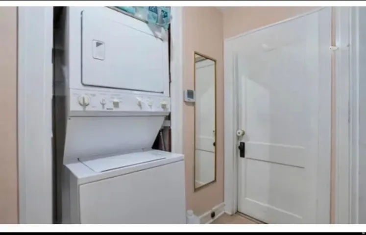 Dedicated laundry area featuring a stacked washer and dryer unit