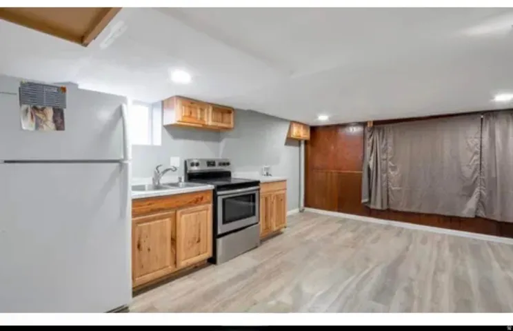Efficient kitchen area featuring wood cabinetry, a stainless steel range, and a full-size refrigerator