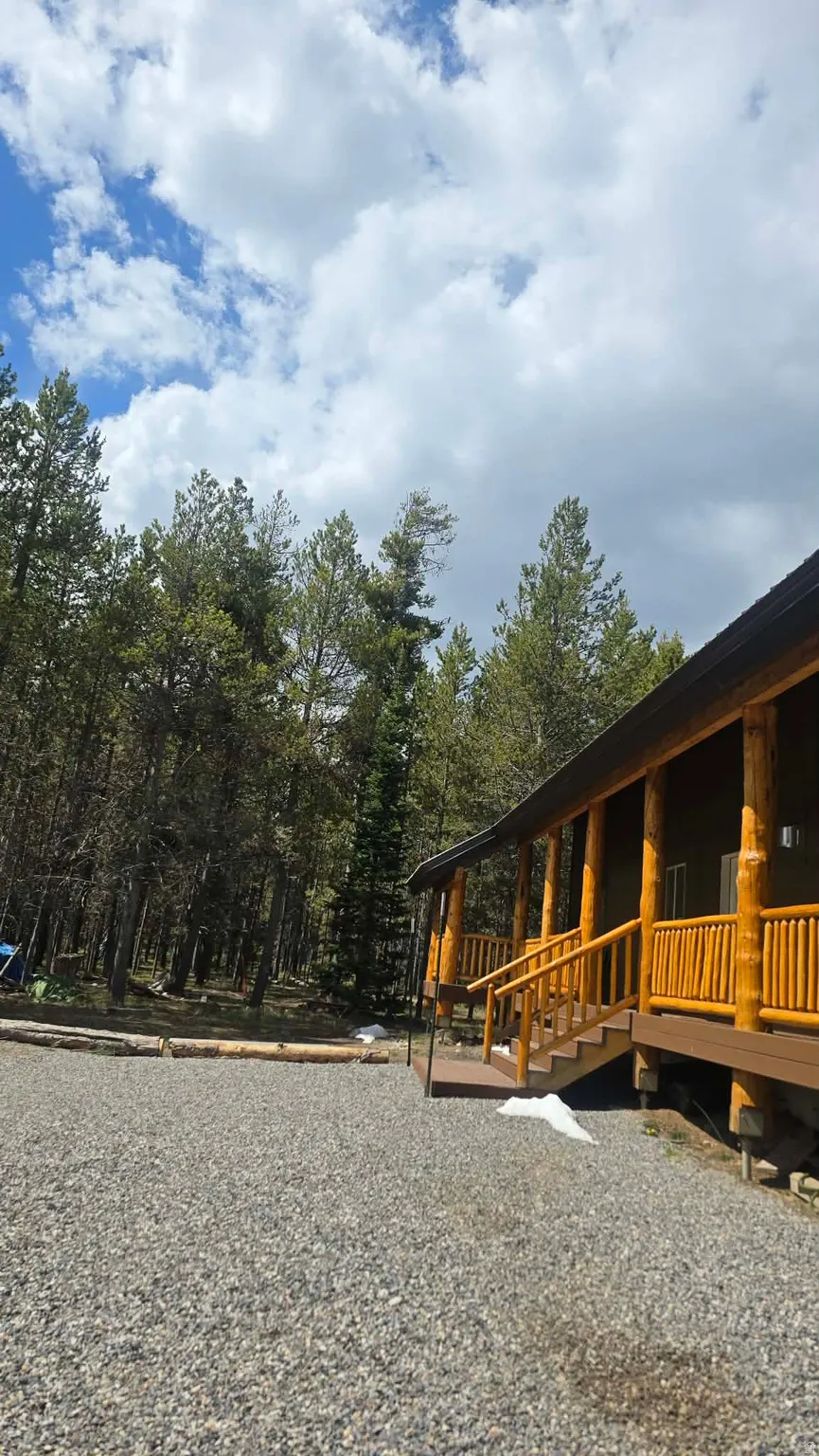 Log cabin exterior with an expansive gravel driveway