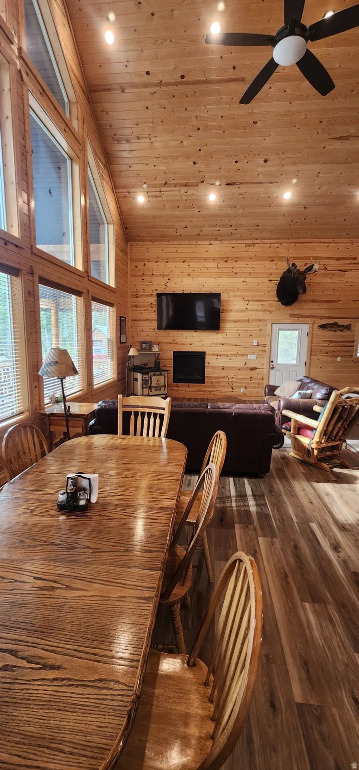 Expansive great room featuring a vaulted wood-paneled ceiling, large picture windows, wood-finish flooring, and a built-in fireplace