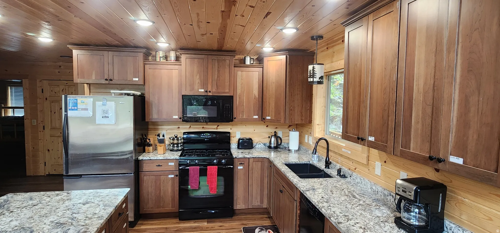 Kitchen featuring wood paneling, wood-finish flooring, and recessed lighting