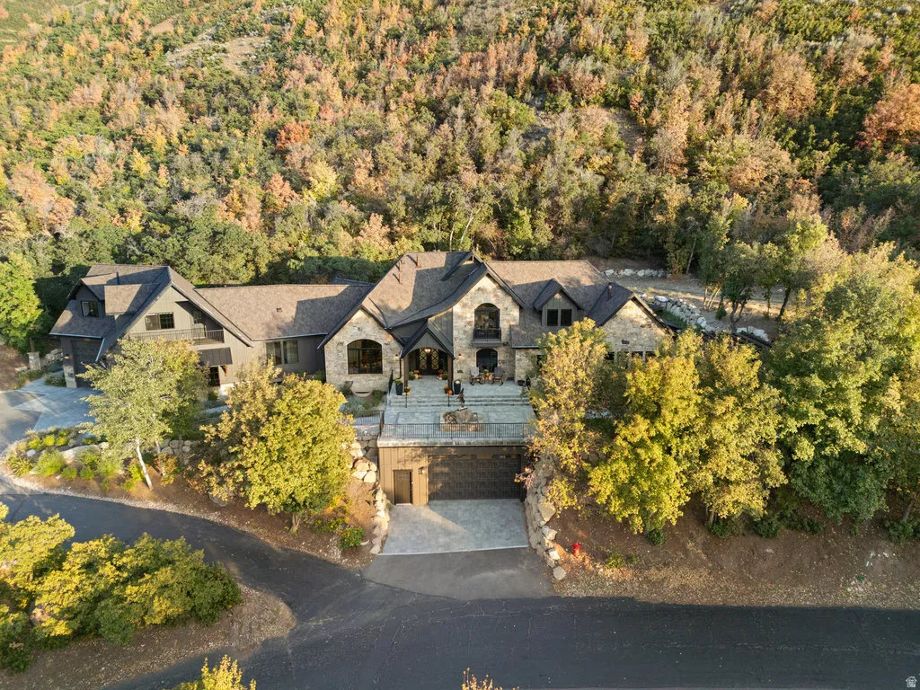 Expansive estate with a multi-gabled roofline and stone and dark siding exterior