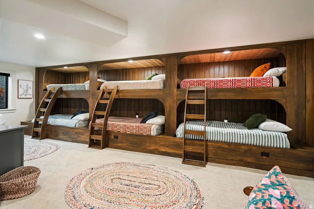BASEMENT Custom built-in bunk beds with rich wood-finish paneling and integrated lighting