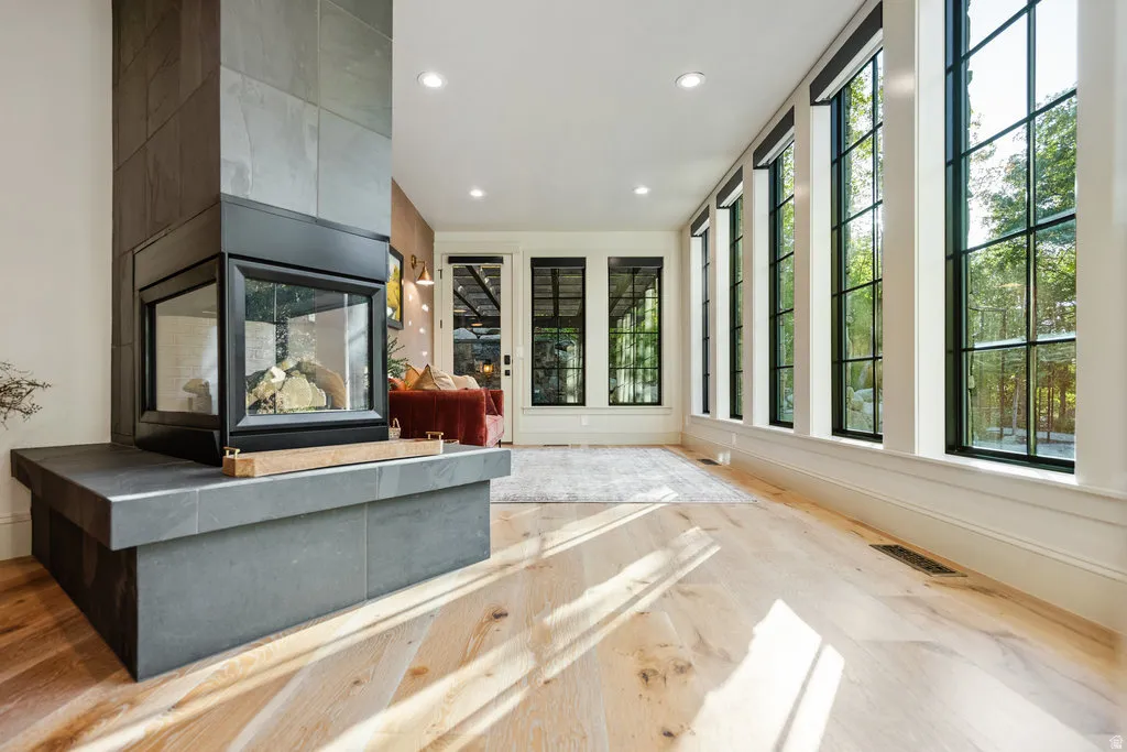 Three-sided glass fireplace with a stone surround