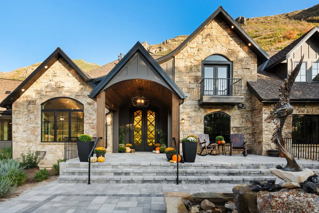 Stone and shingle exterior featuring an arched entryway with wood-finish ceiling, double entry doors, and an overhead lantern-style fixture