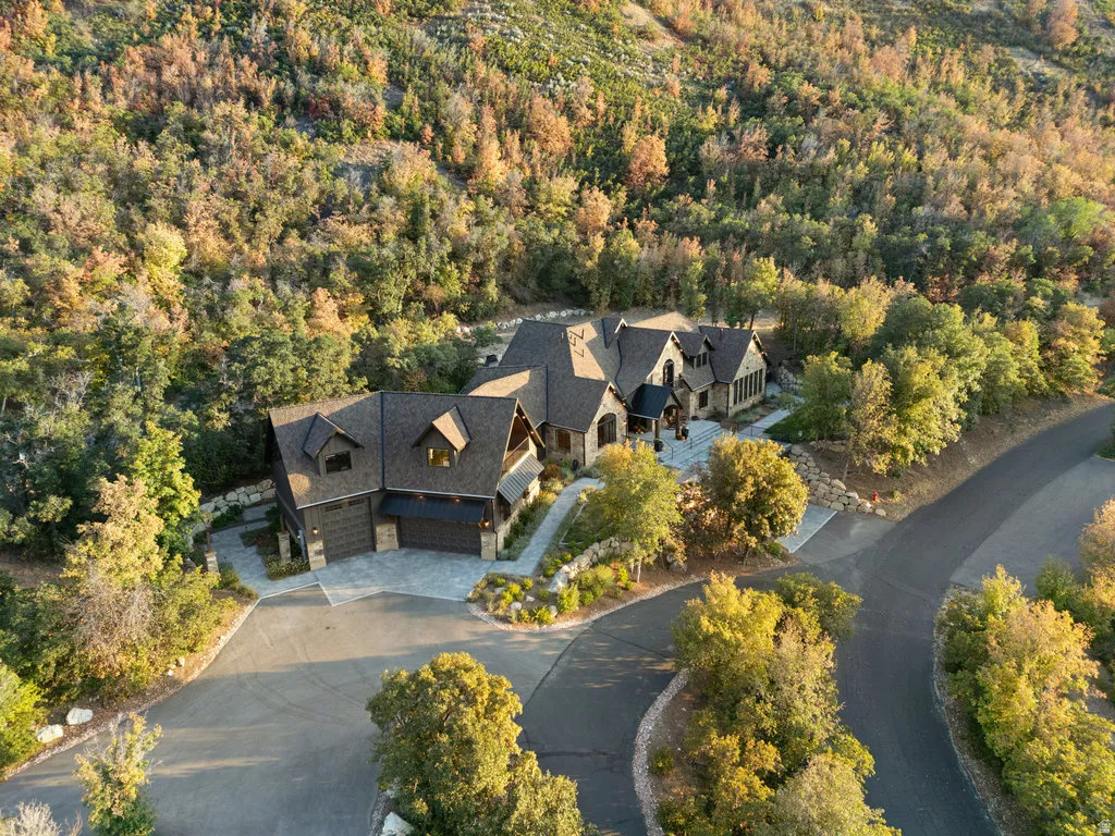 Expansive property featuring a stone and wood-sided exterior, dark shingle roof, multiple gables, and an attached two-car garage