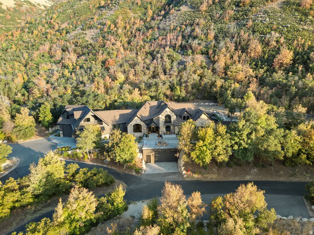 Expansive property featuring a multi-level residence with stone and wood siding
