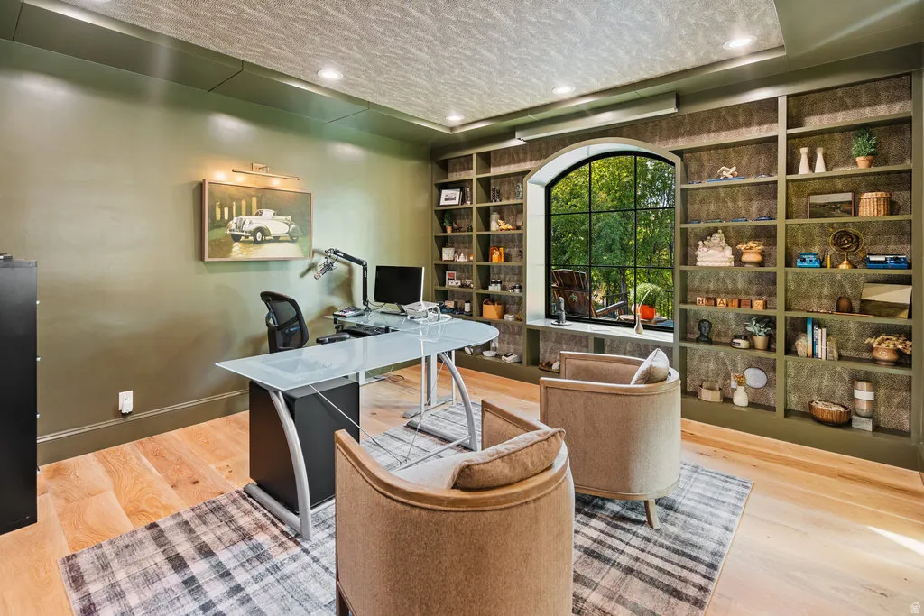 Arched window with black grid surrounded by built-in shelving