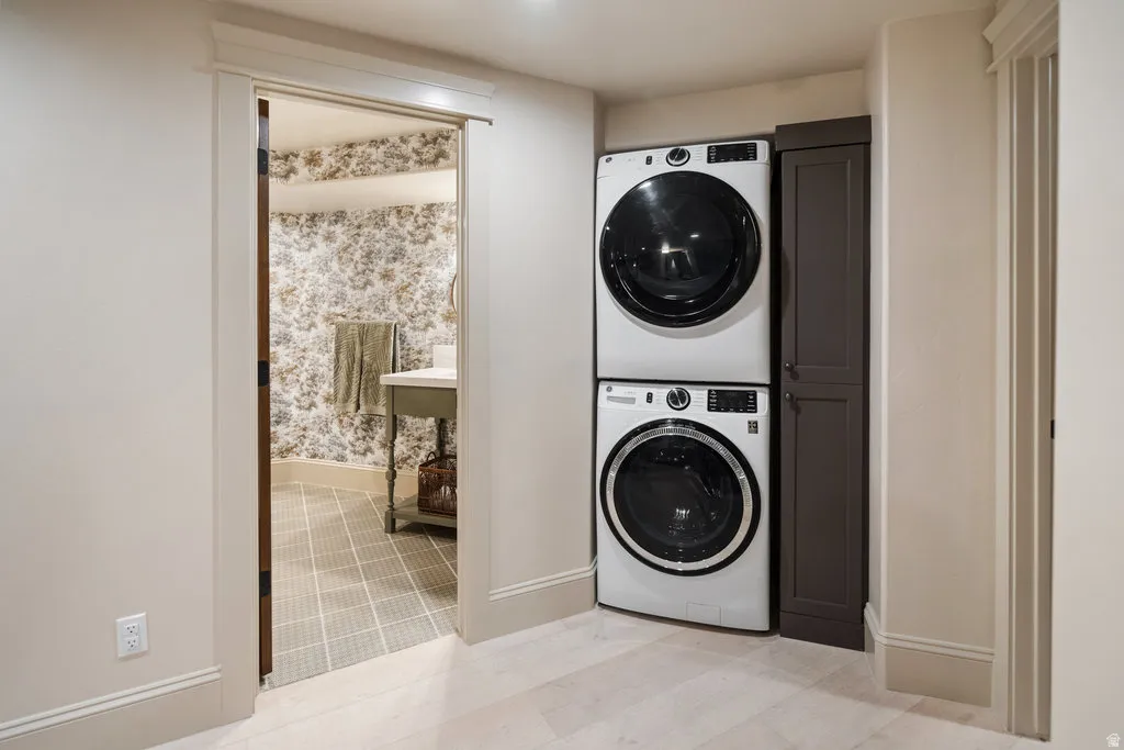 Laundry area featuring stacked front-load machines and an adjacent built-in storage cabinet