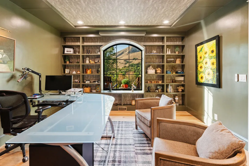 Room featuring an arched window with mountain scenery, built-in shelving, recessed ceiling lighting, and wood-finish flooring