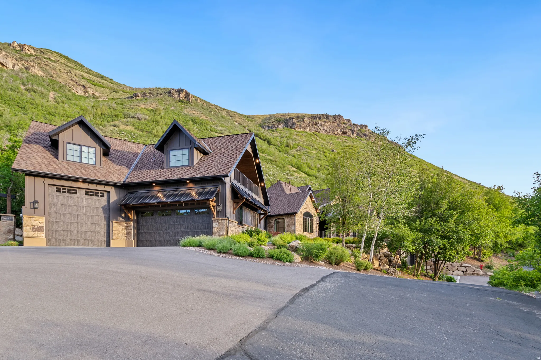 Craftsman-style home featuring a prominent gabled roofline and stone and wood siding